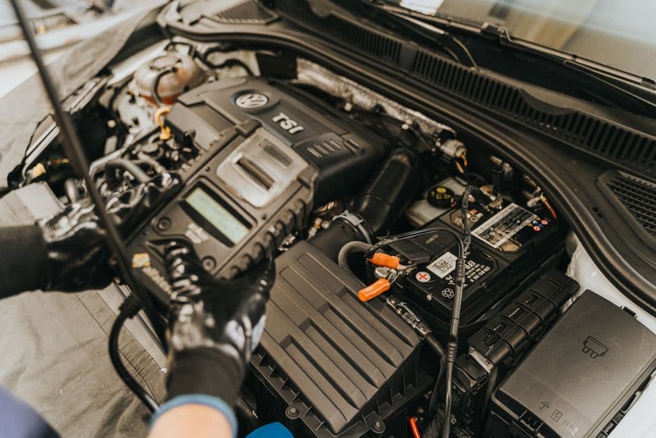 Mechanic running diagnostics on a Volkswagen engine during a scheduled service
