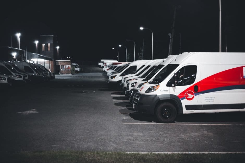 A small fleet of work vans parked in a lot before daily dispatch