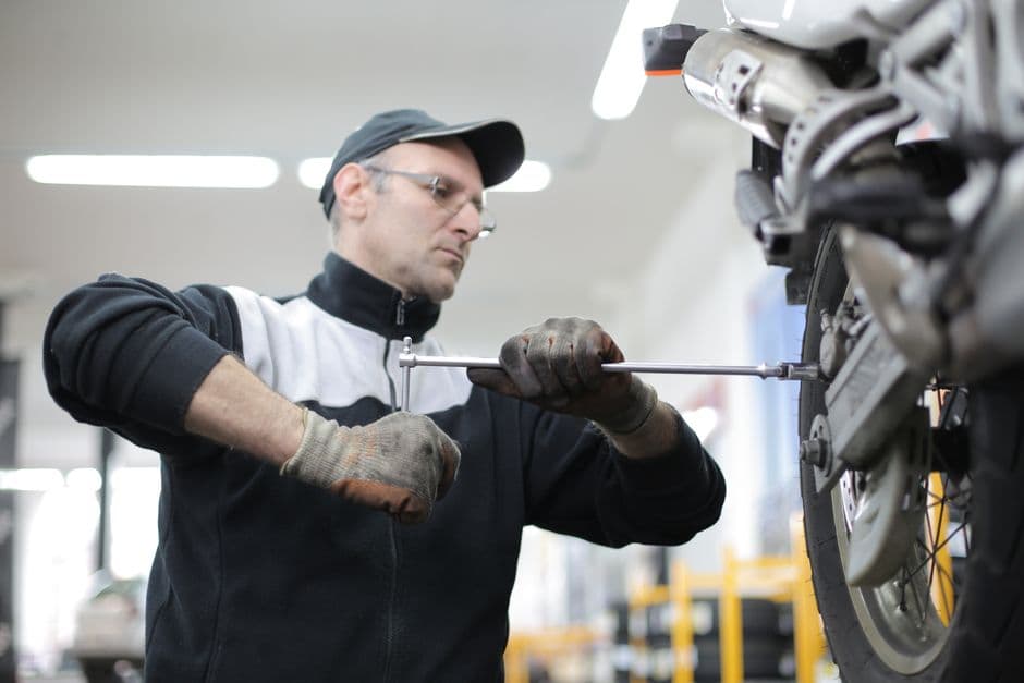 Mechanic repairing a motorcycle tire in a workshop during a tire replacement