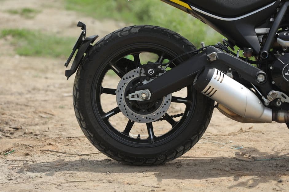 Close-up of a motorcycle rear tire tread showing wear pattern during tire maintenance inspection