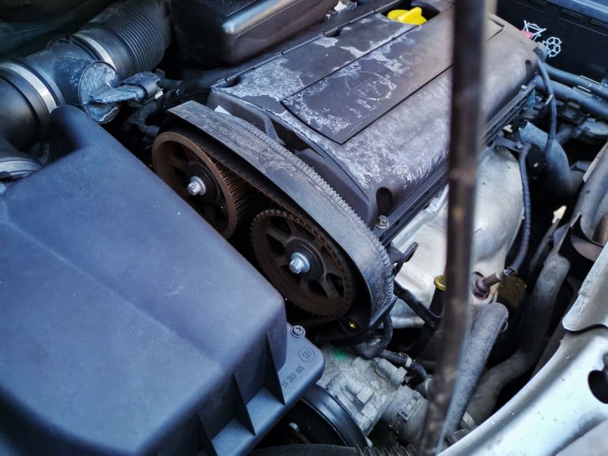 Close-up of a serpentine belt routed around engine pulleys under the hood