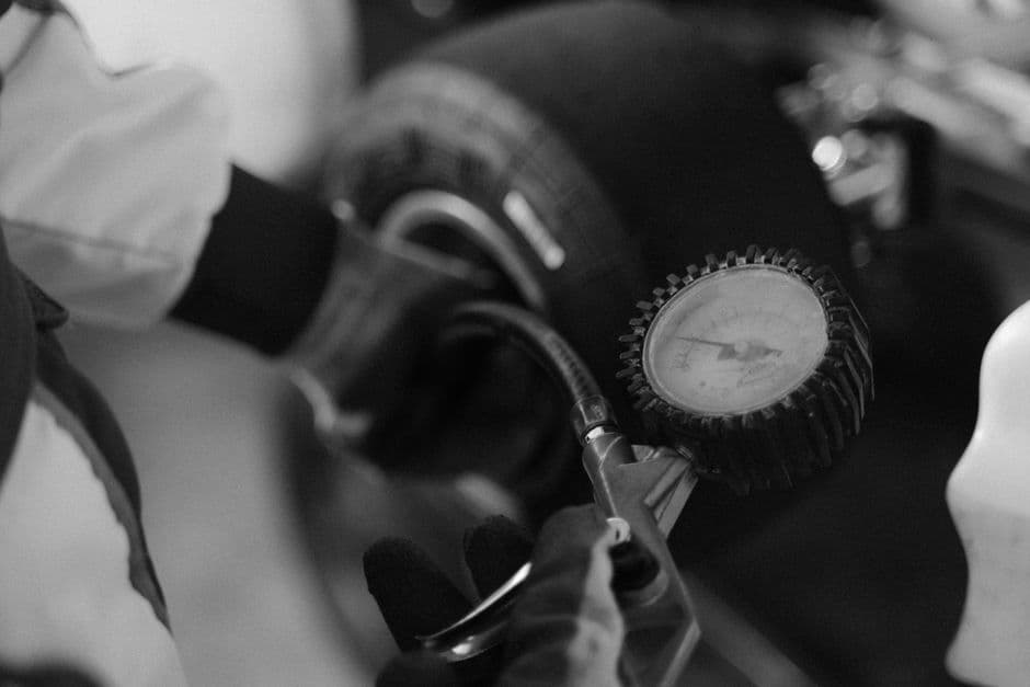 Mechanic checking tire pressure with a gauge as part of TPMS maintenance