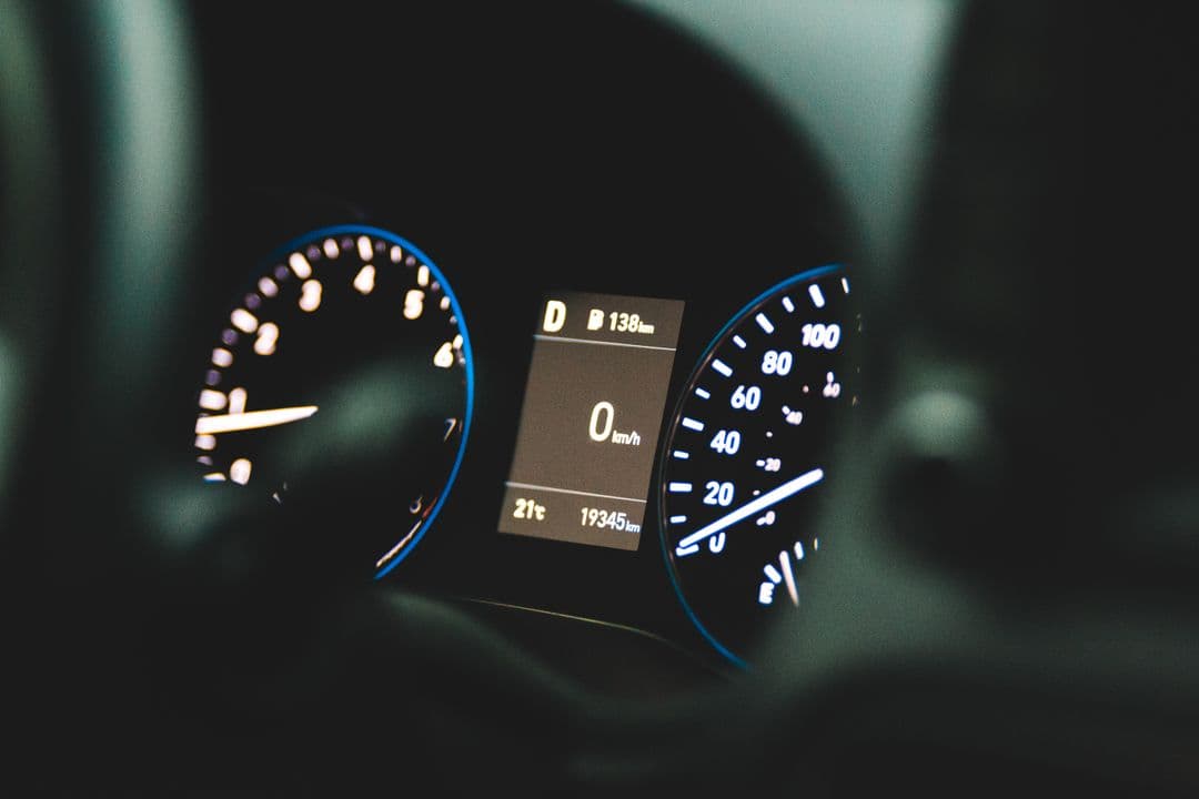 A car dashboard nearing a high-mileage milestone, the trigger for 100,000-mile car maintenance