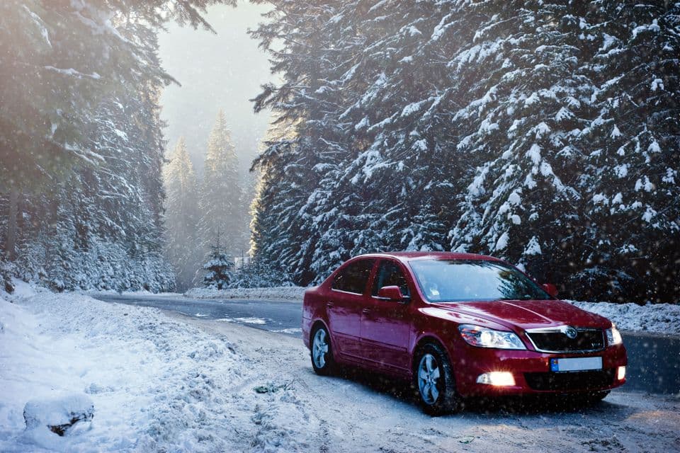 A car on a snowy road, the reason seasonal car maintenance checklists matter twice a year