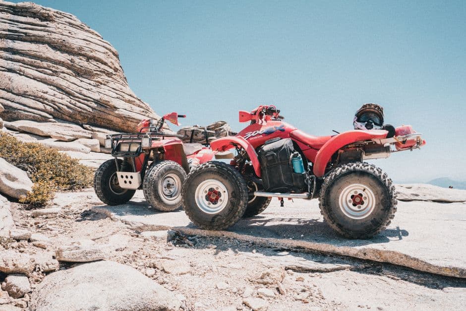 ATVs parked on rocky terrain after a maintenance and tire check