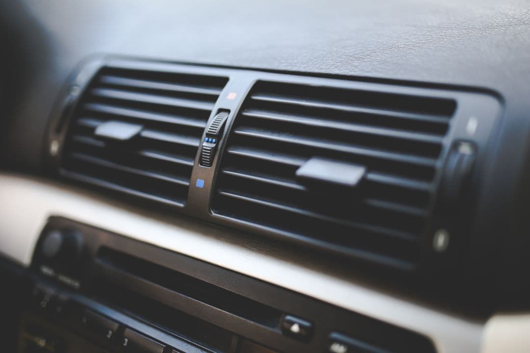 Car air conditioning vents on a dashboard, the visible end of vehicle AC maintenance