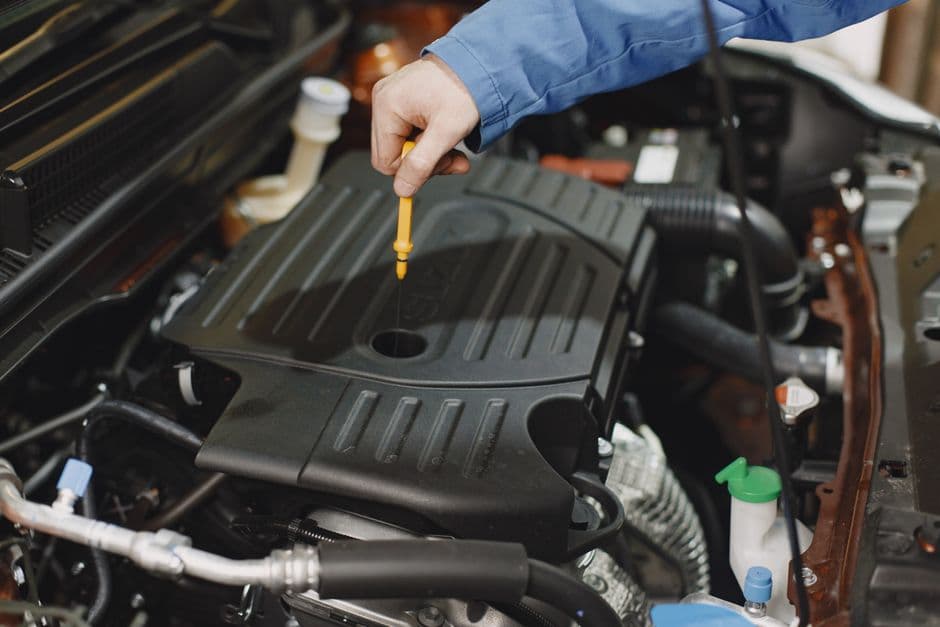 Checking engine oil level with a dipstick as part of routine engine maintenance