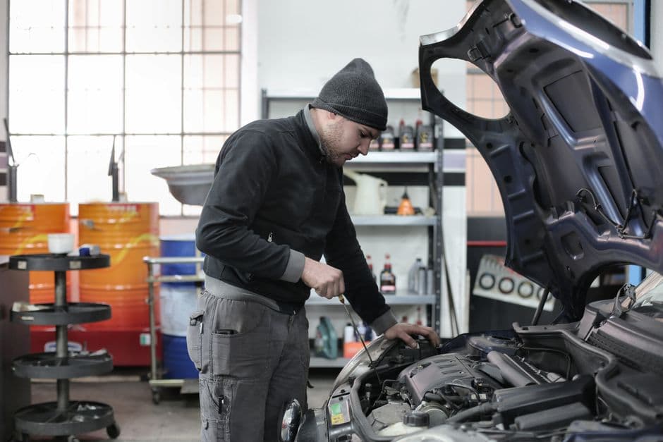 Mechanic checking a car engine for an unexpected repair a maintenance fund should cover