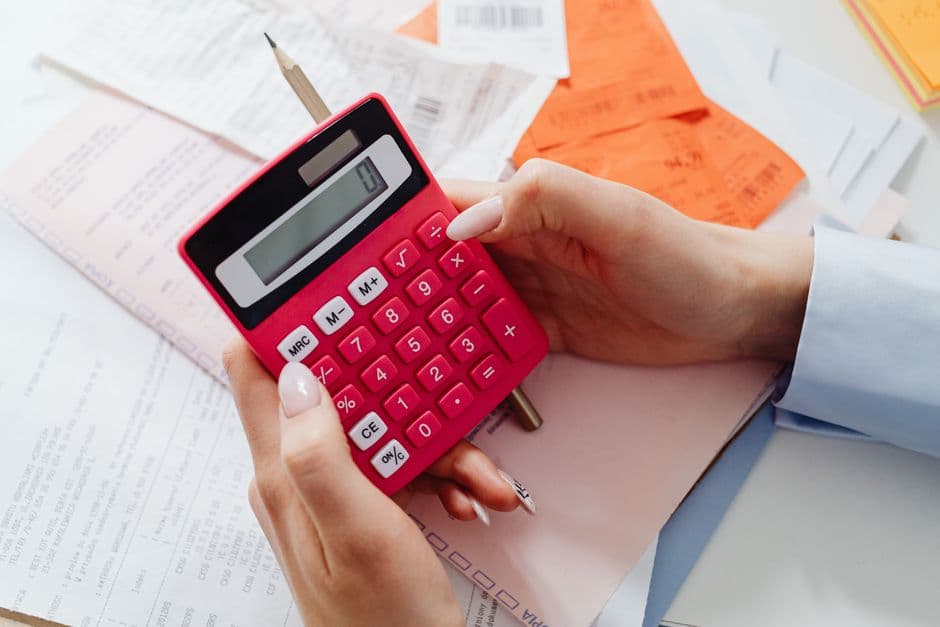Car maintenance receipts and a calculator laid out for tracking upkeep costs by vehicle