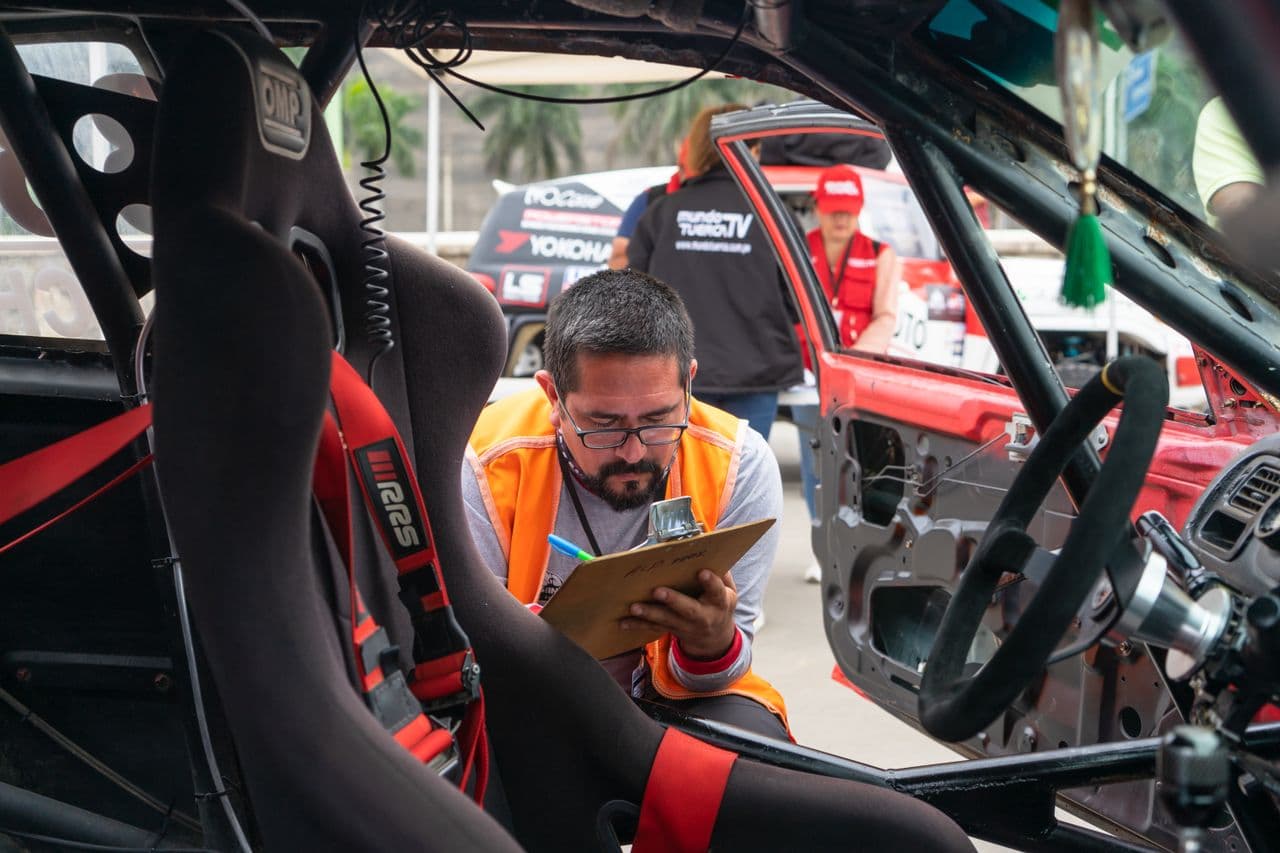 Inspector noting car maintenance findings on a clipboard, the habit a car maintenance log template turns into a record