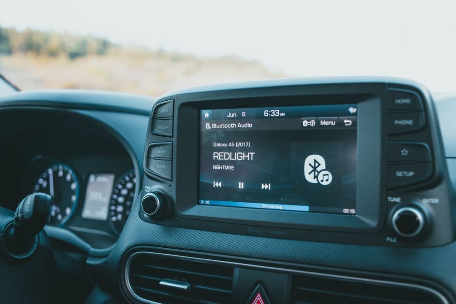 Aftermarket car stereo head unit showing an audio display in a dashboard