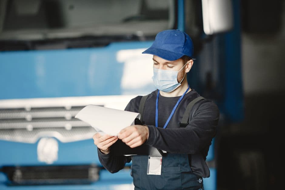 Mechanic reviewing service documents and maintenance paperwork in an auto shop