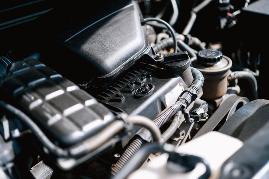 Close-up of engine bay wiring and connectors relevant to a piggyback tuning module