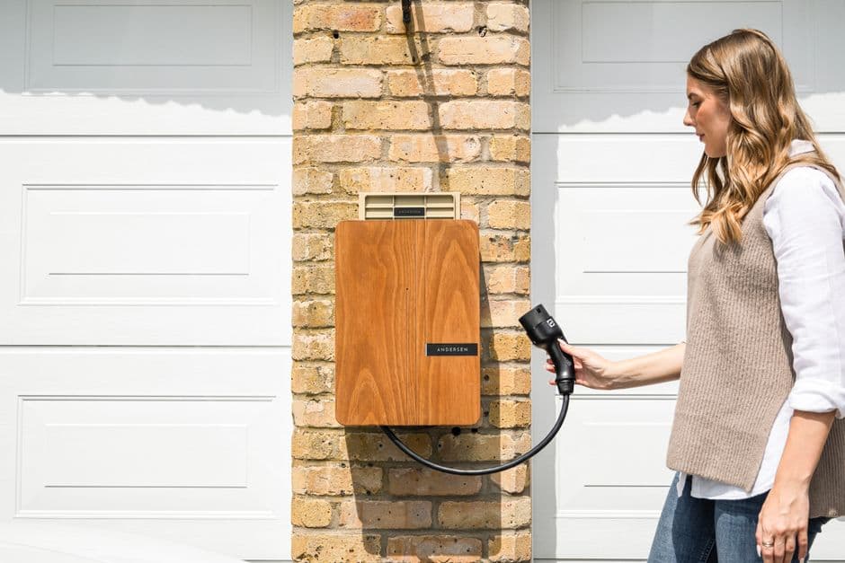Home EV charger mounted on a garage wall with the charging cable connected to an electric vehicle