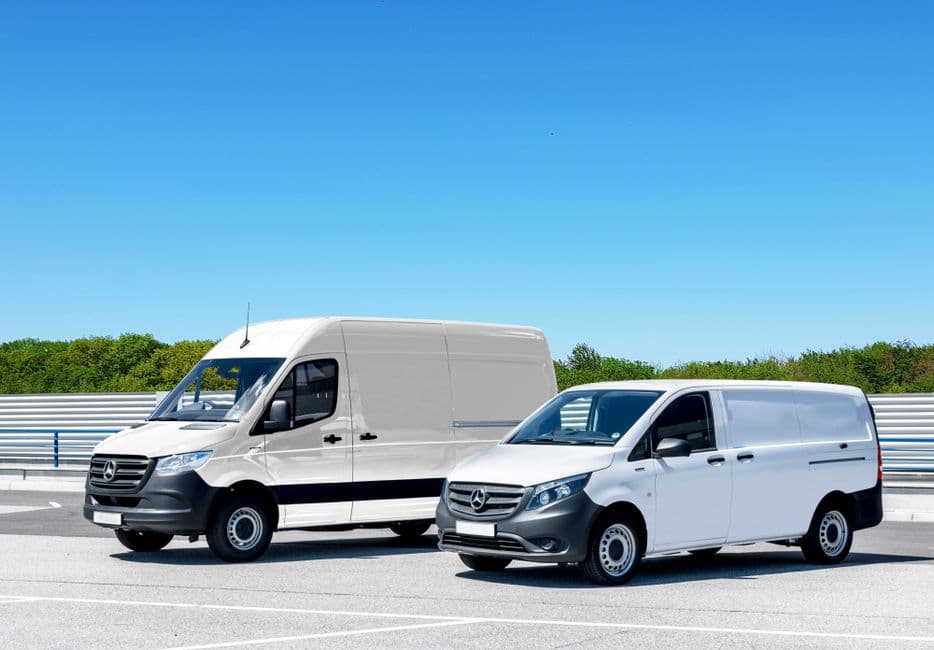 Small fleet of white cargo vans parked together, the kind of fleet where maintenance cost tracking pays off