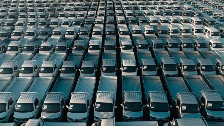 Aerial view of fleet pickup trucks parked in rows awaiting scheduled maintenance