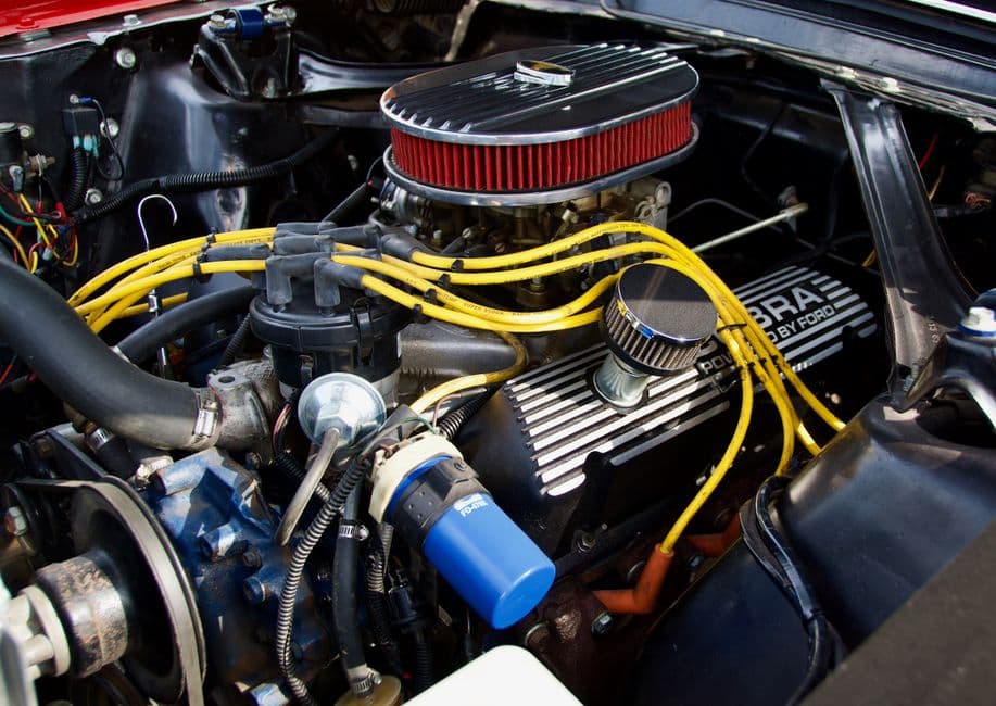Close-up of a fuel injector on a car engine during fuel system maintenance