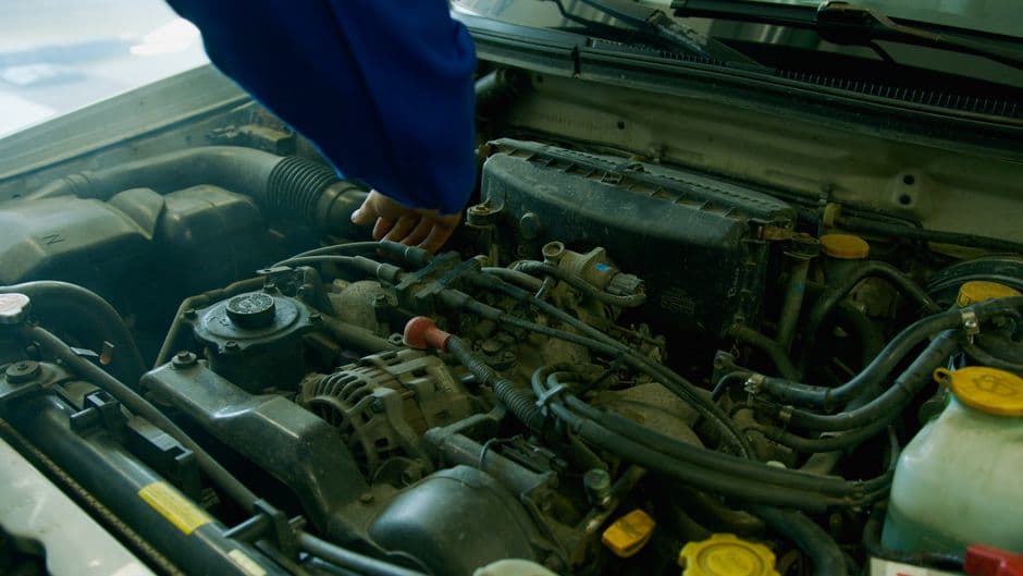 Mechanic inspecting an engine bay as part of fuel system maintenance