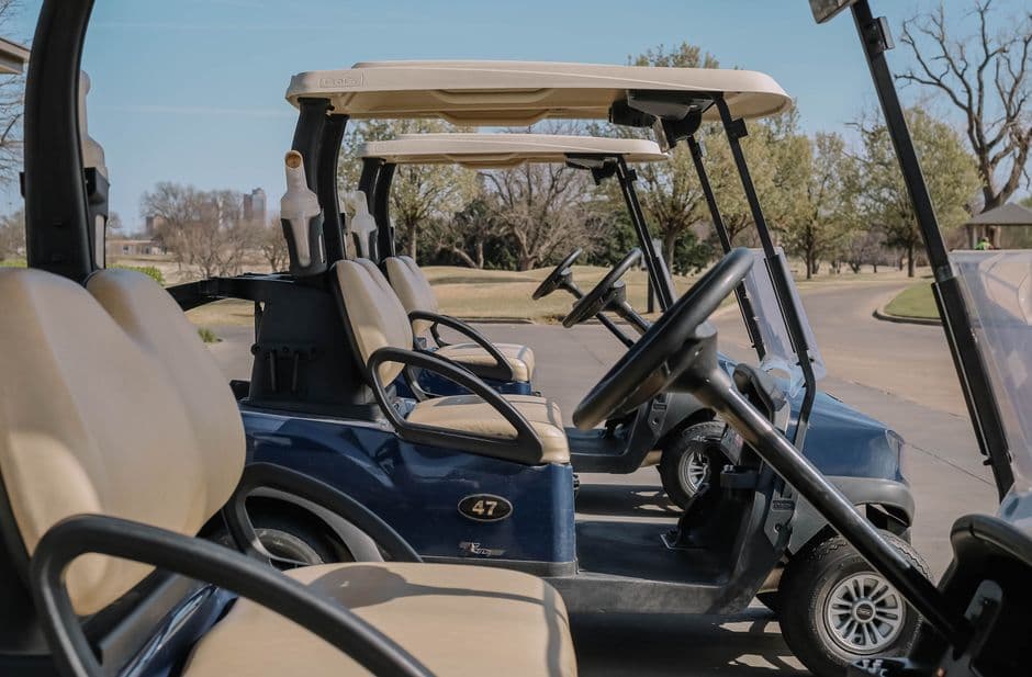 Golf carts parked outdoors in a charging and storage area