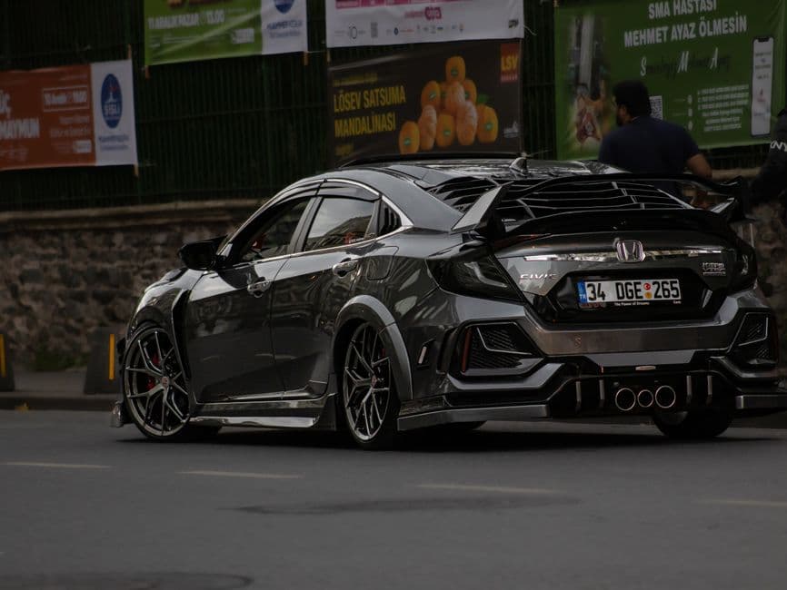 Modified Honda Civic on lowered suspension and aftermarket wheels on a city street