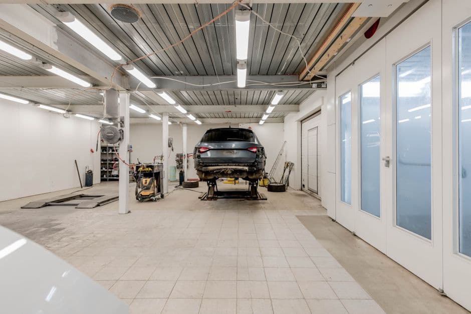 Car on a hydraulic lift in a garage bay waiting for scheduled maintenance