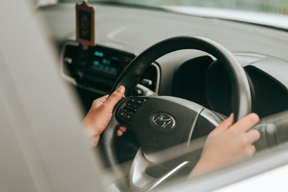 Driver keeping both hands on the wheel while driving a manual car