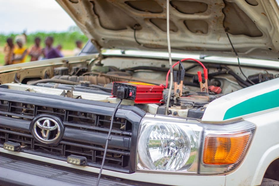 Battery tender connected to a car battery in the engine bay for storage