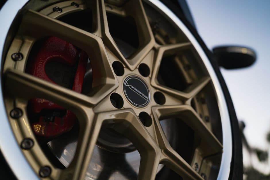 Gold alloy car wheel and red brake caliper showing clearance after a rim upgrade