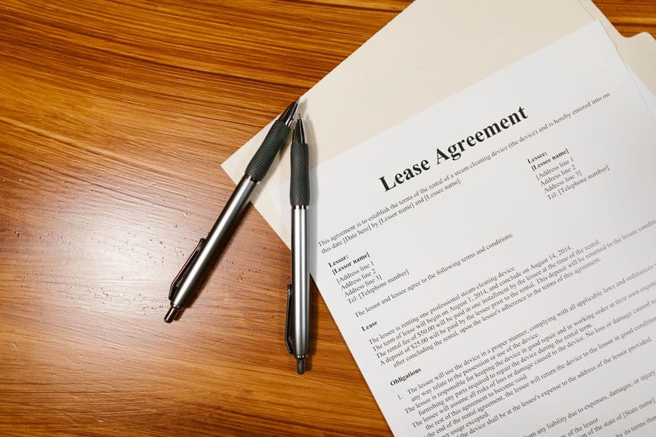 Lease agreement paperwork and pen on a wooden desk