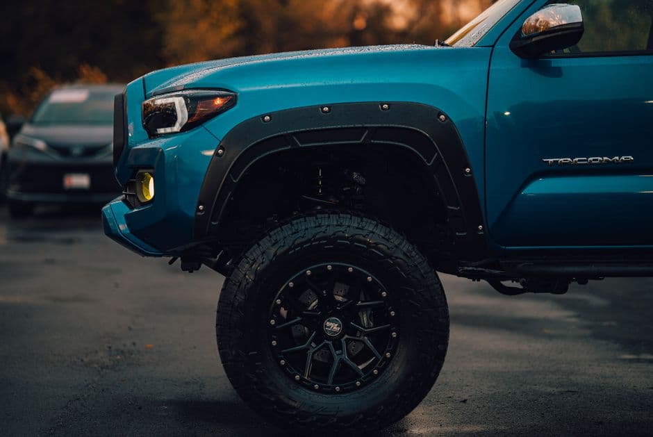 Detailed side view of a lifted off-road truck's tire and suspension setup