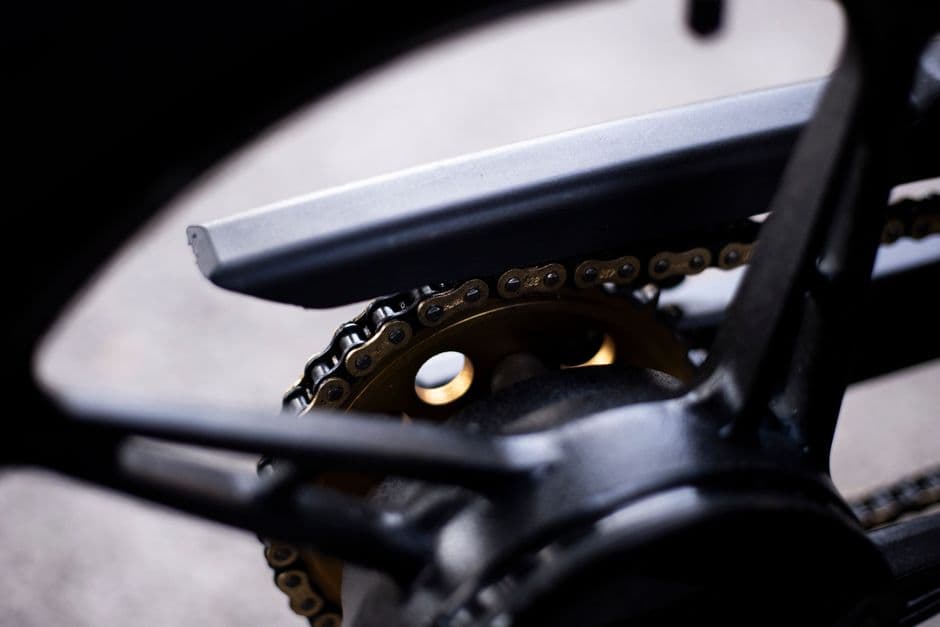 Close-up of a motorcycle chain and rear sprocket during chain maintenance