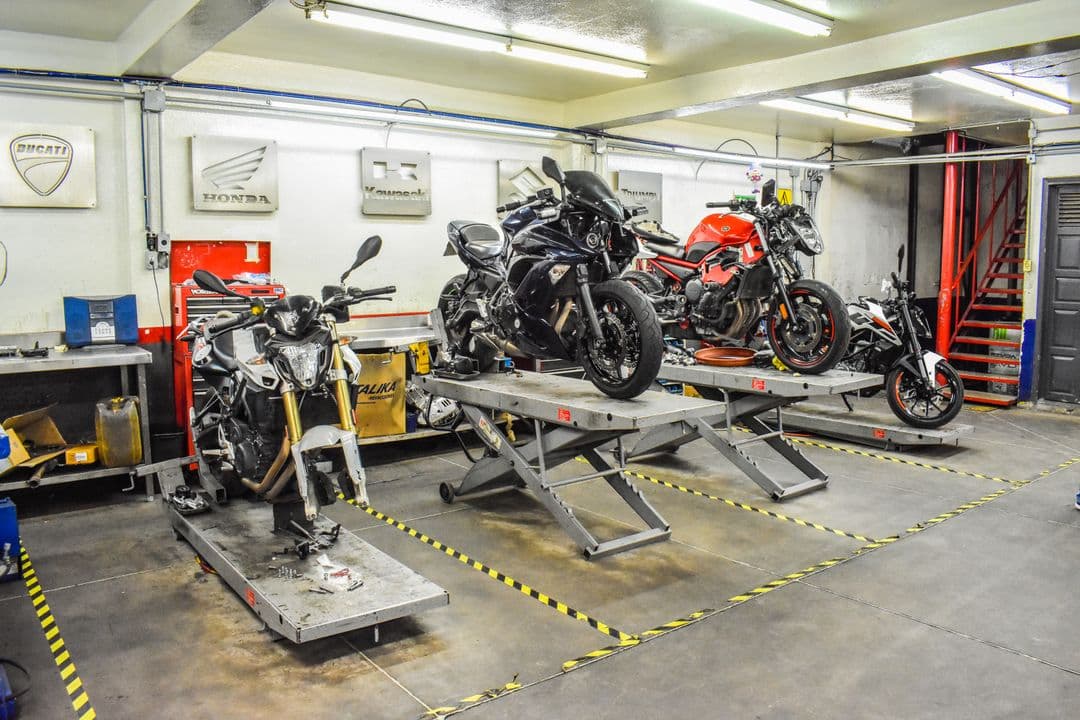 Motorcycles on stands in a repair shop during routine motorcycle maintenance