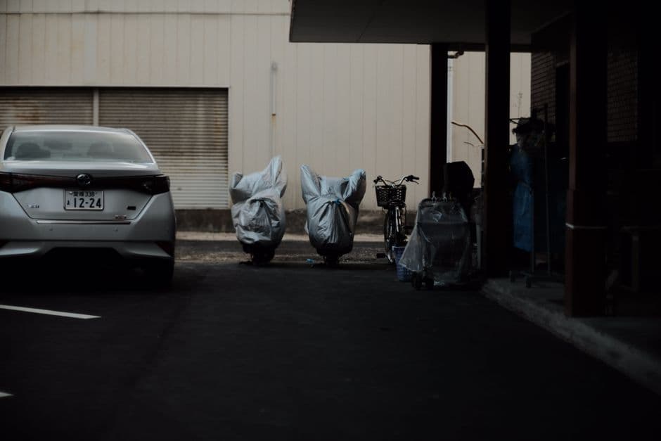 Motorcycles covered for winter storage parked in a dimly lit garage