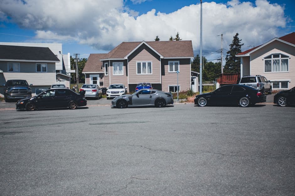Suburban street with several household vehicles parked along the curb