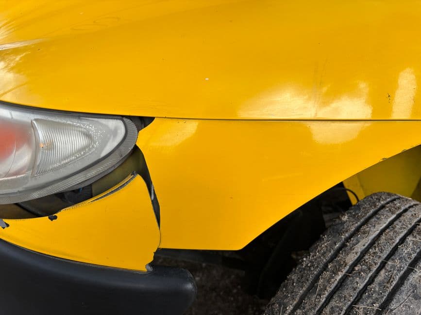Close-up of a damaged car bumper, the kind of pre-repair photo worth keeping in a repair record