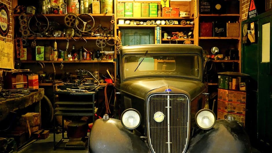 Classic project car surrounded by hand tools in a home workshop