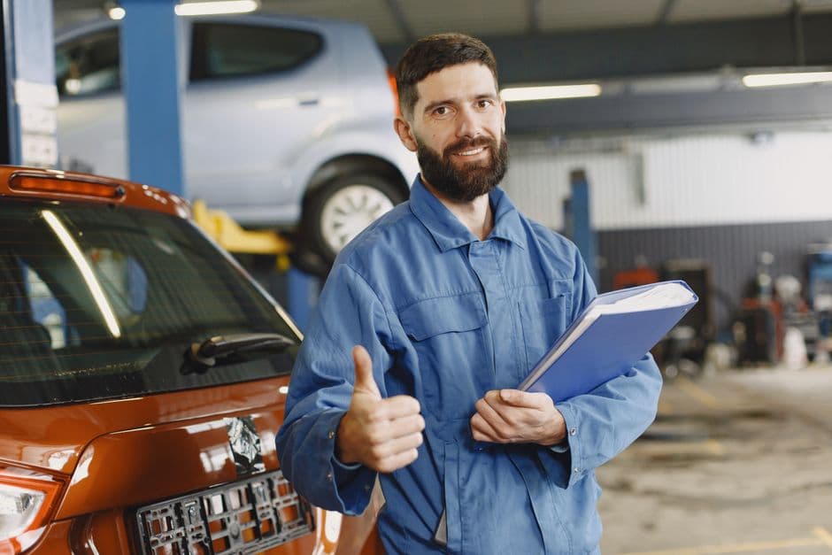 Mechanic in a garage holding a clipboard, the habit that keeps a build log template accurate as a project car progress log