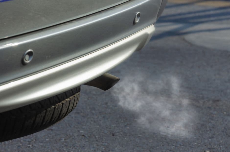 Close-up of a car exhaust pipe during an emissions test, the kind of check a smog test measures