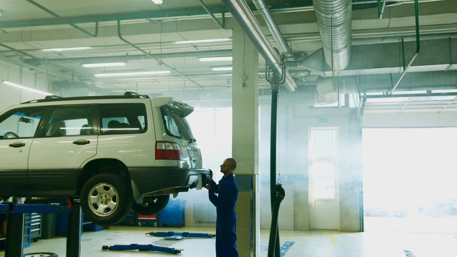 Mechanic conducting a vehicle inspection related to an emissions or smog test