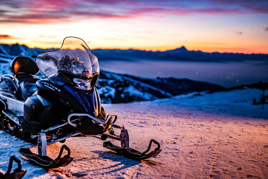 Close-up shot of a snowmobile showing the track, hood, and body panels