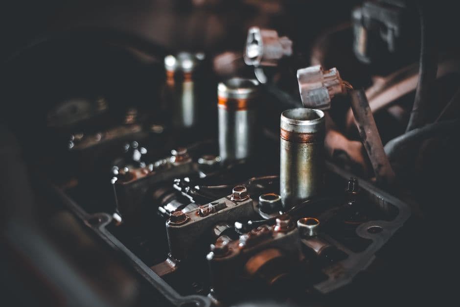Close-up of a spark plug being removed from a car engine for replacement