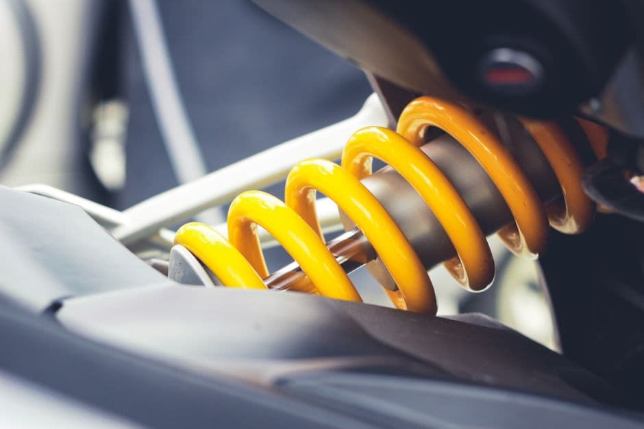 Close-up of a yellow coilover spring, a common car suspension upgrade part