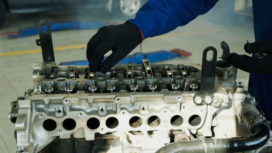 Mechanic inspecting engine components during a timing belt maintenance job