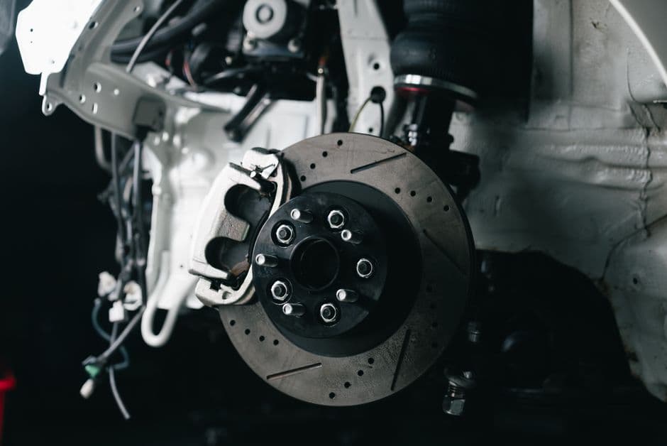 Close view of a disc brake caliper and rotor during a brake pad inspection