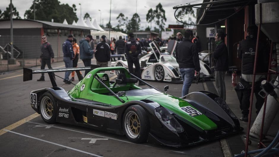 Race cars being prepared in the pit lane before a track day session