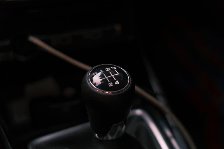 Close-up of a manual transmission gear shifter showing the gear pattern