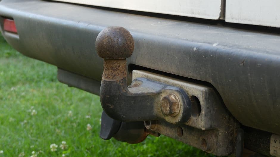 Close-up of a trailer hitch and coupler, one of the connection points checked during trailer maintenance