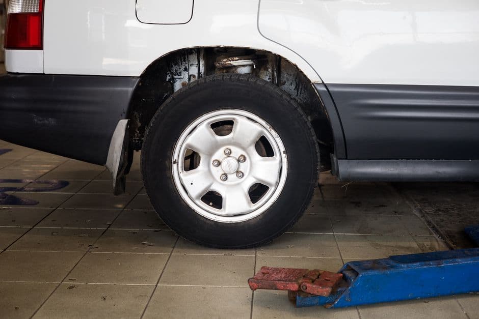 Technician performing a tire and wheel alignment service on a lift