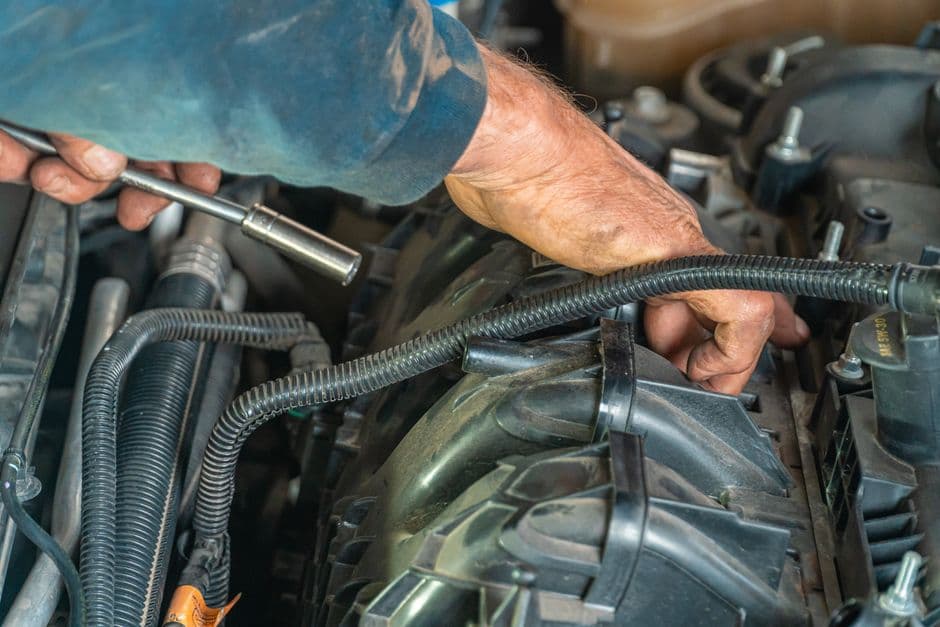 Mechanic repairing a car engine under warranty at a service shop