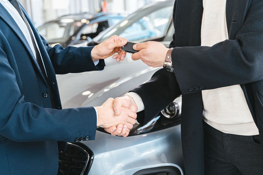 Handing over car keys at a sale, where a documented maintenance history increases resale value